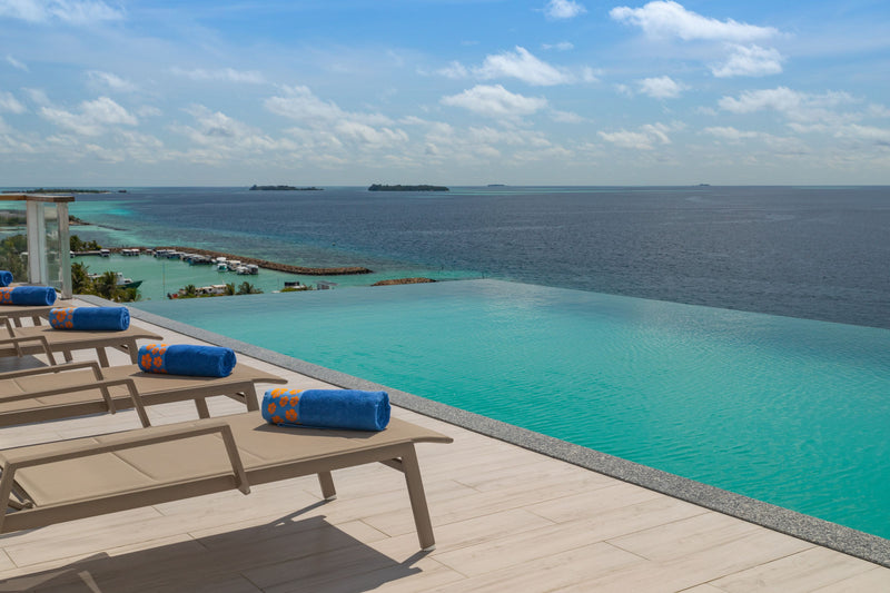 Sun loungers along the edge of the infinity pool at Kaani Palm Beach