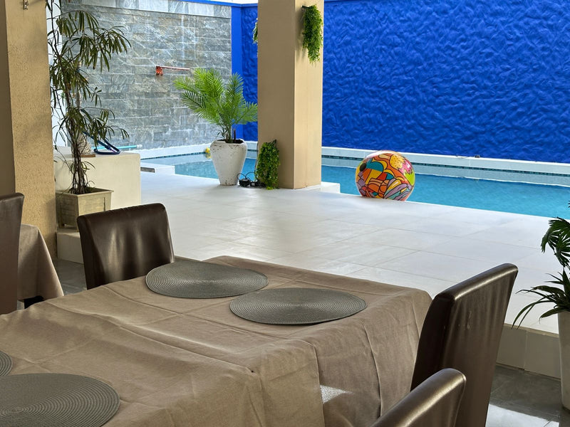 Table set for a meal next to the pool at KUE Hotel
