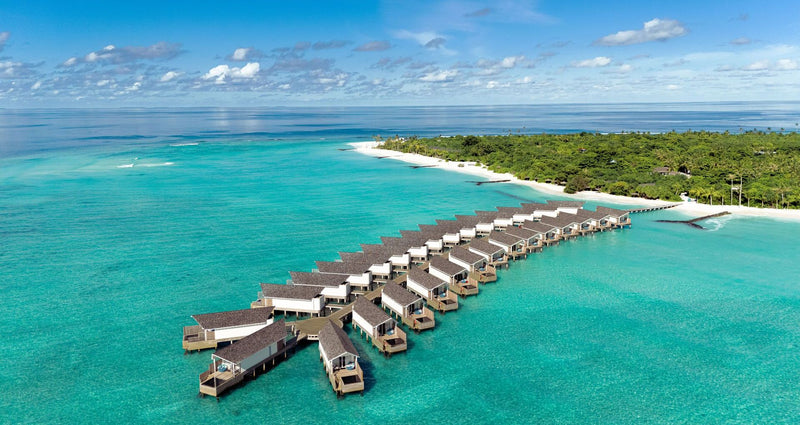 RAAYA by Atmosphere, Raa Atoll: from the air, a row of water villas off the beach