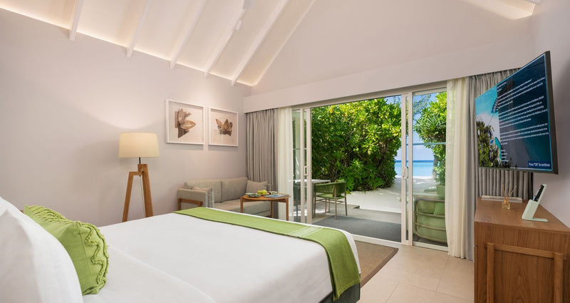 RAAYA by Atmosphere, Raa Atoll: a beach villa bedroom opening onto the garden