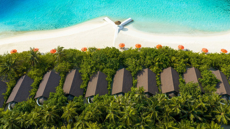 OBLU SELECT Sangeli, North Malé Atoll: from above, a row of beach villa roofs behind the beach and its umbrellas