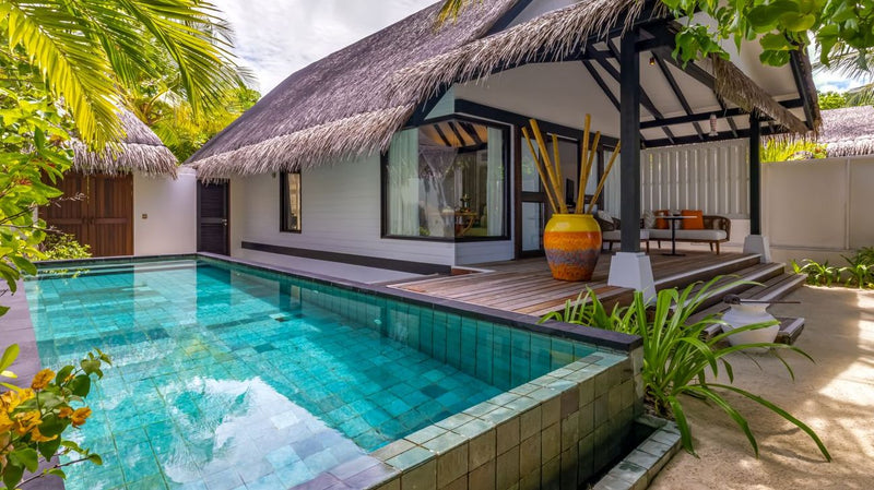 An Earth Villa with Pool at OZEN LIFE Maadhoo, the private pool running alongside the thatched villa and its shaded terrace