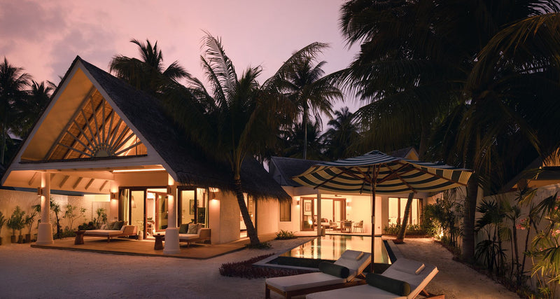 A villa among the palms at dusk at RAH GILI Maldives.