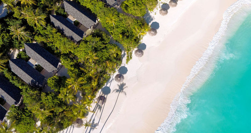 RAAYA by Atmosphere, Raa Atoll: from above, beach villa roofs and umbrellas along the beach