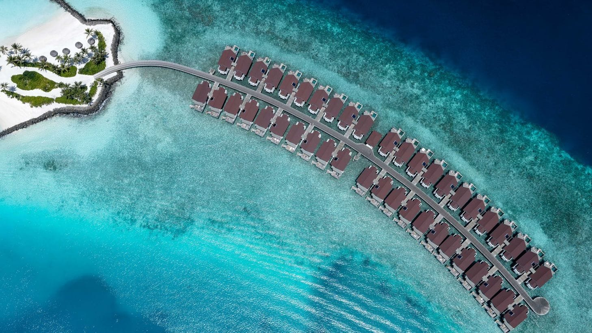 OBLU SELECT Lobigili, North Malé Atoll: the curving row of overwater villas over the reef, from directly above