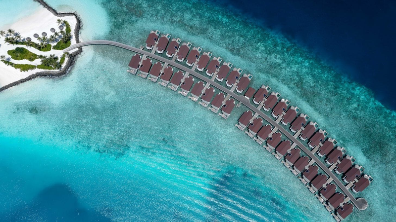 OBLU SELECT Lobigili, North Malé Atoll: the curving row of overwater villas over the reef, from directly above