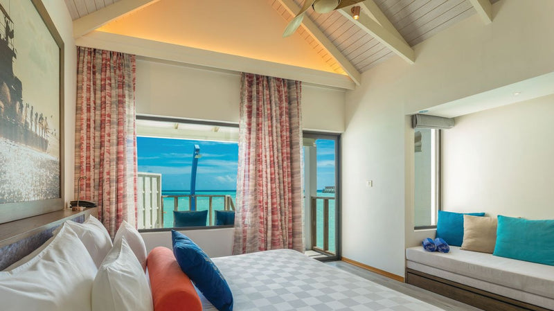OBLU Xperience Ailafushi, North Malé Atoll: a Water Villa bedroom under a sloped ceiling