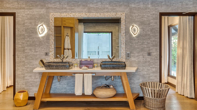The bathroom of an Earth Villa with Pool at OZEN LIFE Maadhoo, twin stone basins on a timber console below a lit mirror
