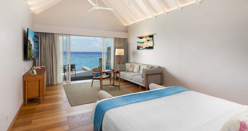 RAAYA by Atmosphere, Raa Atoll: a water villa bedroom with a sofa and sea view