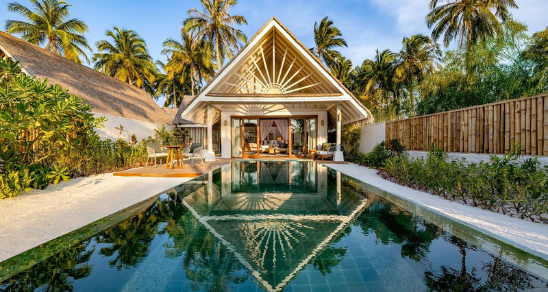 A beach villa and its pool at dusk at RAH GILI Maldives.