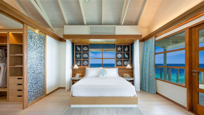OBLU SELECT Lobigili, North Malé Atoll: a Nest Water Villa bedroom under a timber ceiling