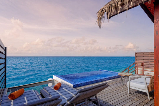 A Reef Pool Water Villa deck at Grand Park Kodhipparu with a plunge pool, loungers and the sea beyond
