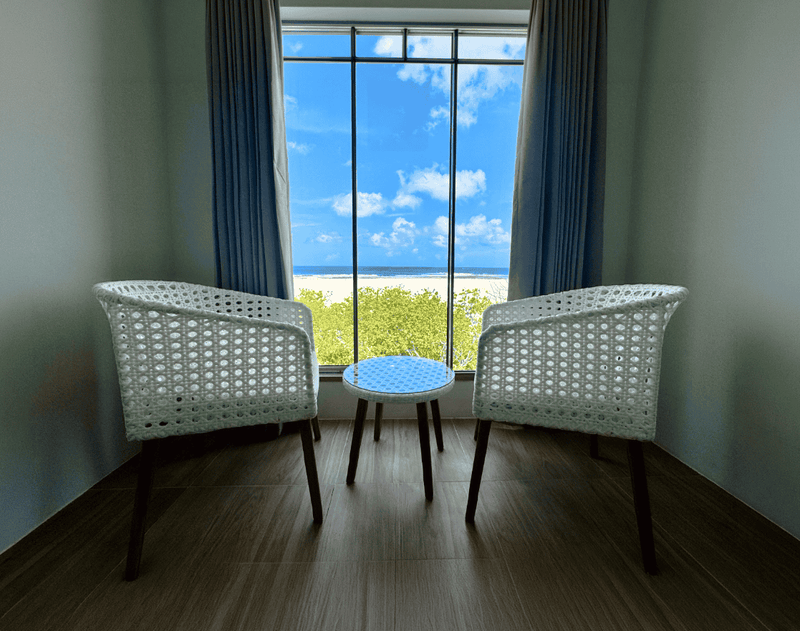 Seating corner by the window in a room at Avyanna Gulhi Beach Hotel