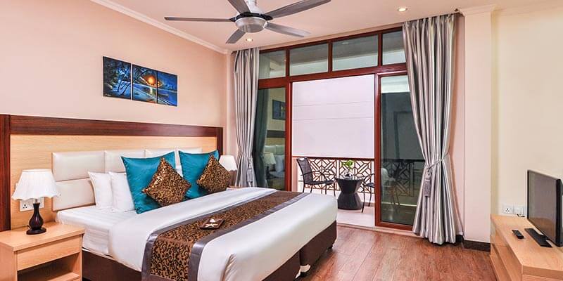 Room at Triton Beach Hotel with a TV unit and large windows