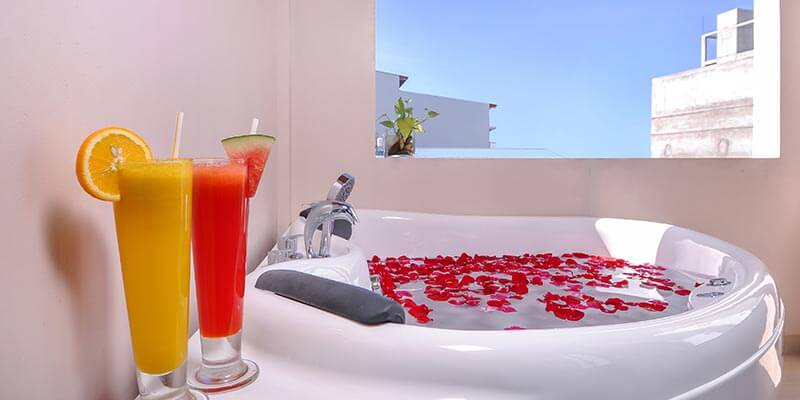 Suite at Triton Beach Hotel with a seating area beyond the bed