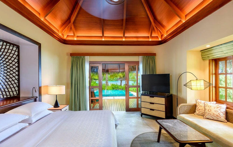 A Cottage with Pool at Sheraton Maldives Full Moon, green curtains and doors opening onto the pool terrace.