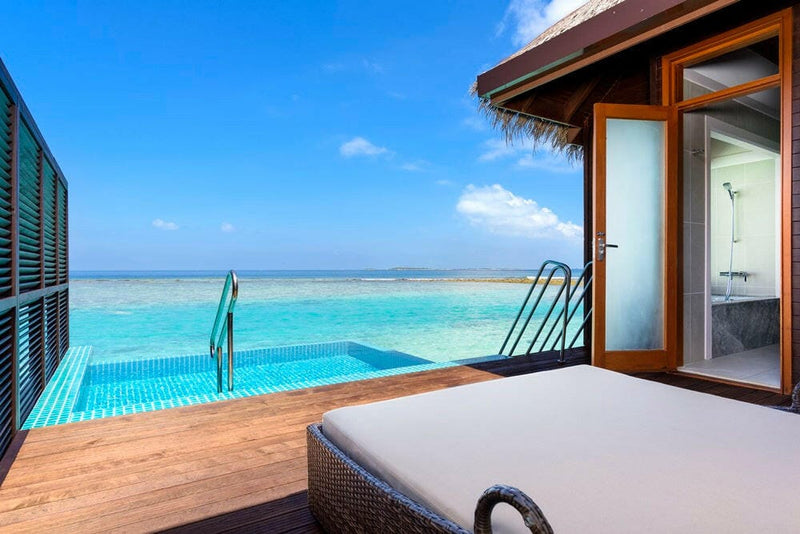 A villa plunge pool at Sheraton Maldives Full Moon, a daybed at the water's edge facing the open lagoon.