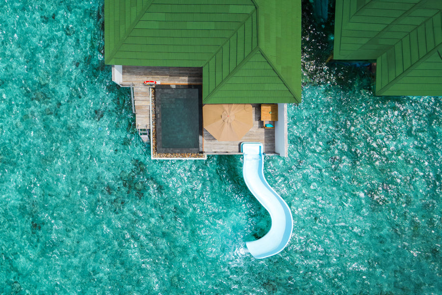 A Lagoon Villa with Pool + Slide at Siyam World from the air, its pool and slide over the lagoon