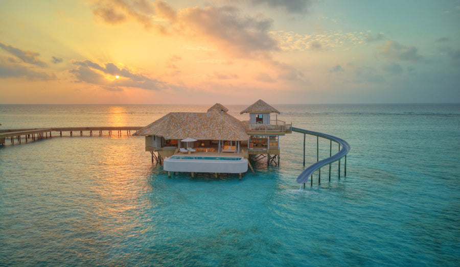 An overwater villa at Soneva Secret at sunset