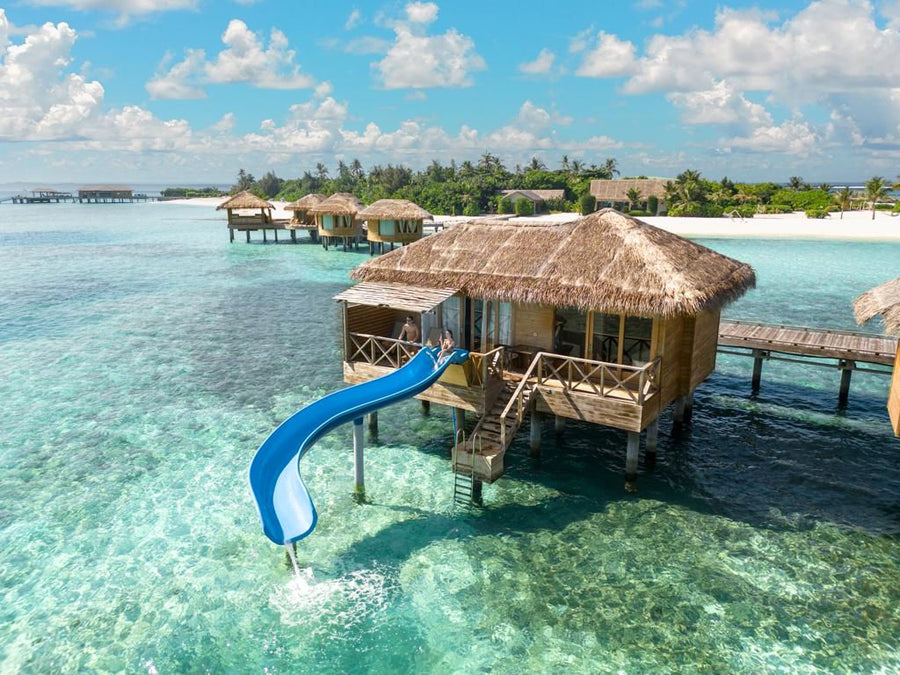 An overwater suite with a water slide at You & Me Maldives