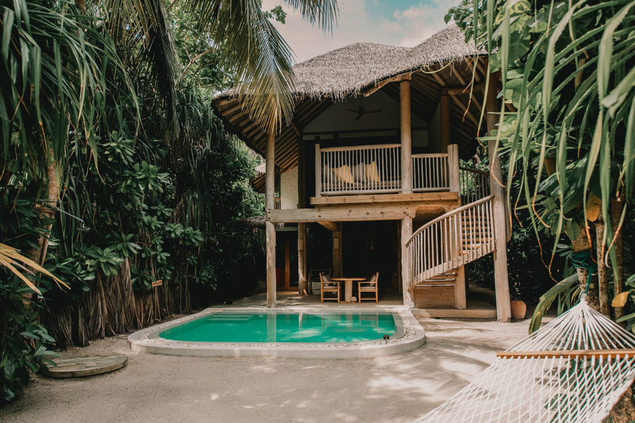 A Crusoe Suite with Pool at Soneva Fushi, a two-storey wooden villa above its private pool in the jungle