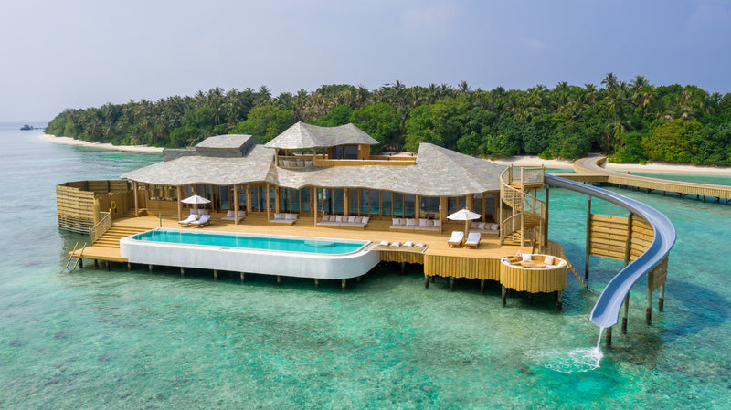 A Two Bedroom Water Reserve with Slide at Soneva Fushi, a large overwater villa with a long pool and a slide into the lagoon