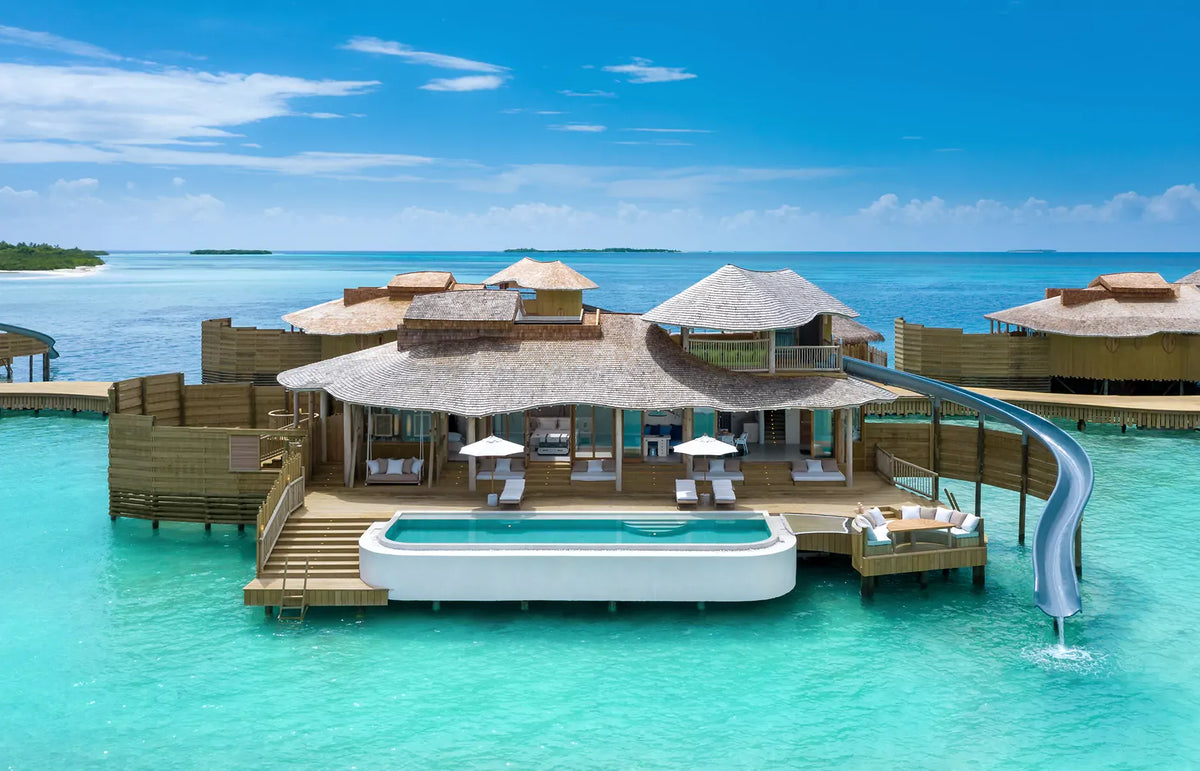 An overwater villa at Soneva Jani, its curved thatched roof above a private pool and deck