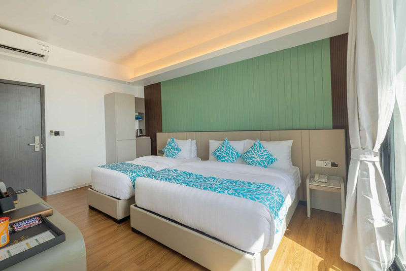 Double bed and seating area in a Standard Deluxe room at Arena Beach Hotel