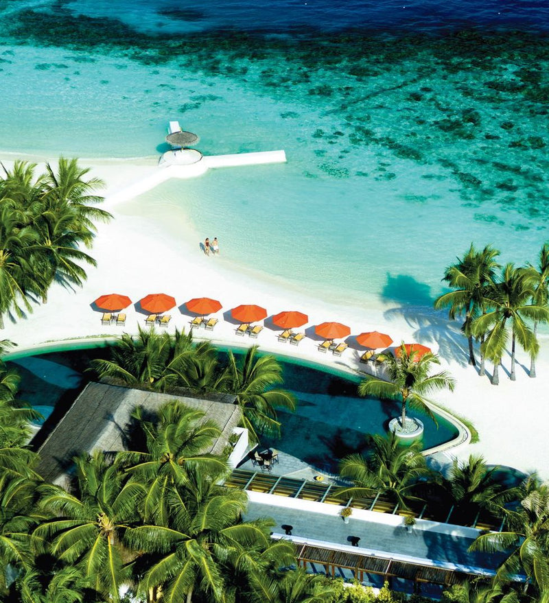 OBLU SELECT Sangeli, North Malé Atoll: from above, the main pool and its row of orange umbrellas beside the beach