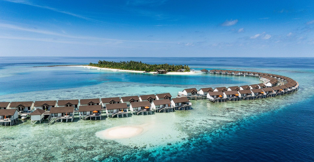 OBLU SELECT Sangeli, North Malé Atoll: the island from the air, with its curving row of overwater villas