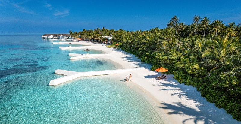 OBLU SELECT Sangeli, North Malé Atoll: the beach and lagoon, with a sundeck jetty and umbrellas along the sand