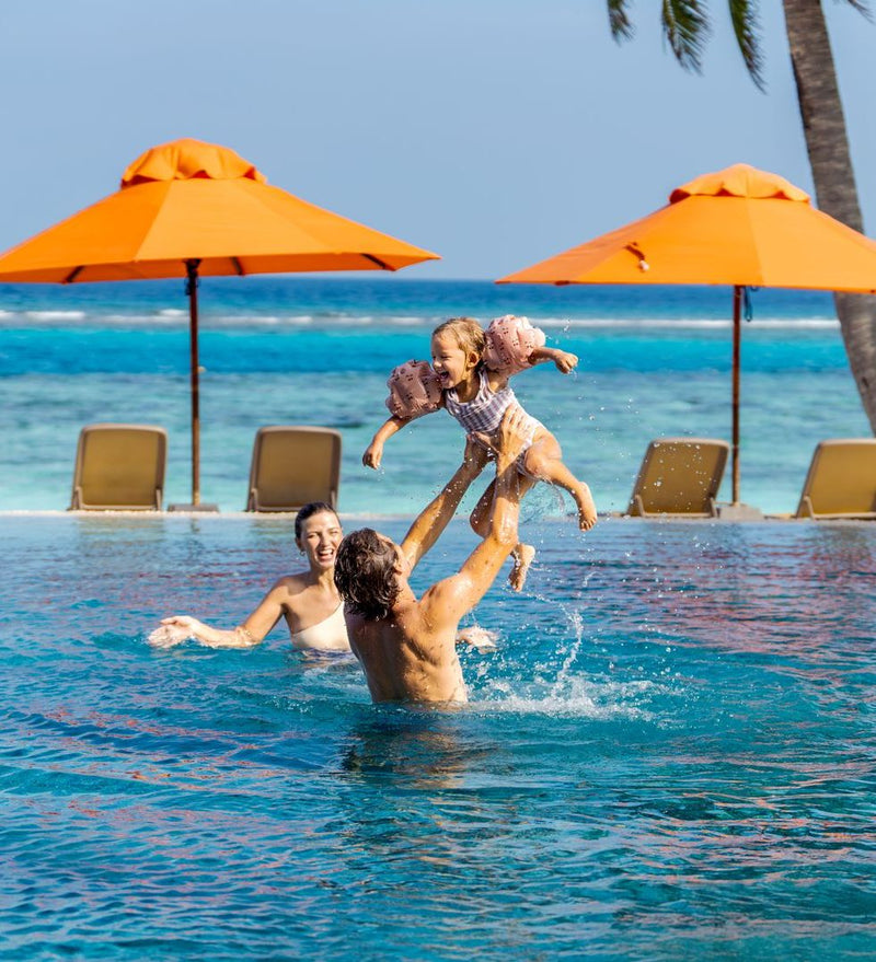 OBLU SELECT Sangeli, North Malé Atoll: parents throwing their daughter into the air in the main pool