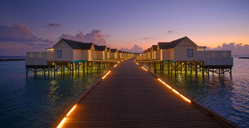 OBLU NATURE Helengeli by SENTIDO, North Malé Atoll: the lit jetty to the water villas at dusk