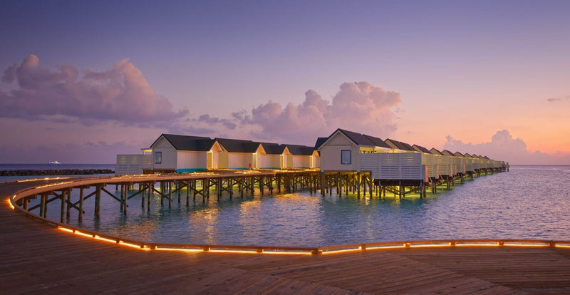 OBLU NATURE Helengeli by SENTIDO, North Malé Atoll: the water villas at dusk, with the jetty lit