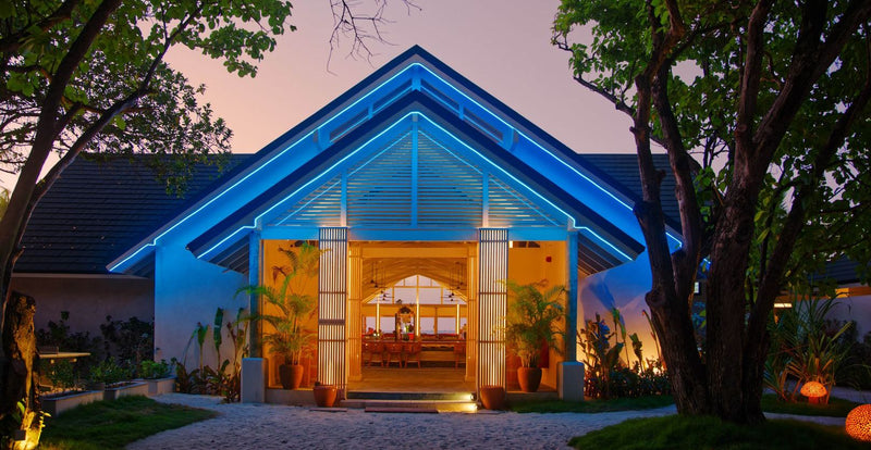 OBLU NATURE Helengeli by SENTIDO, North Malé Atoll: the lit entrance of a restaurant among trees at dusk