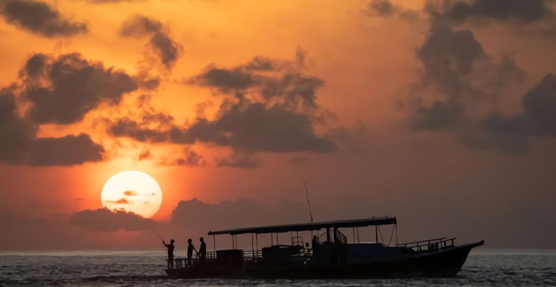 OBLU NATURE Helengeli by SENTIDO, North Malé Atoll: a traditional boat silhouetted against a red sunset