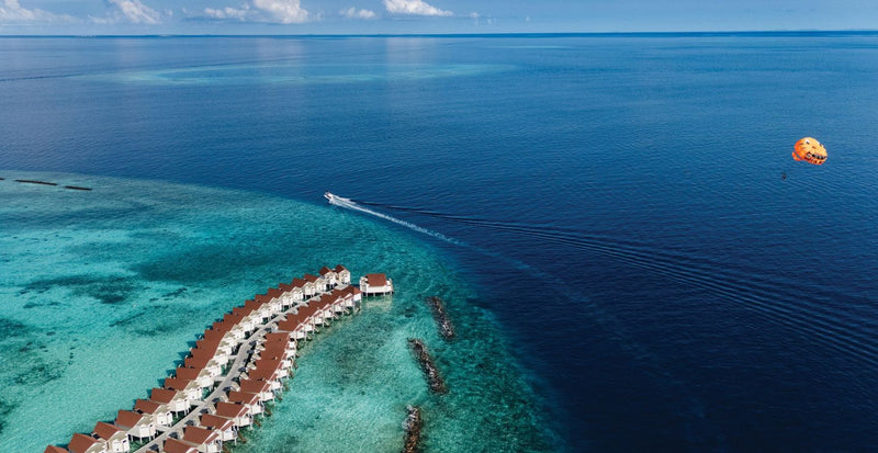 OBLU Xperience Ailafushi, North Malé Atoll: a parasail above the lagoon near the overwater villas