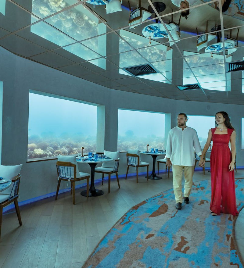 OBLU Xperience Ailafushi, North Malé Atoll: a couple walking through Only Blu, the underwater restaurant