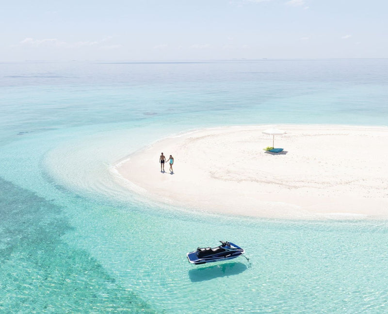 VARU by Atmosphere, North Malé Atoll: a couple on a sandbank in the lagoon