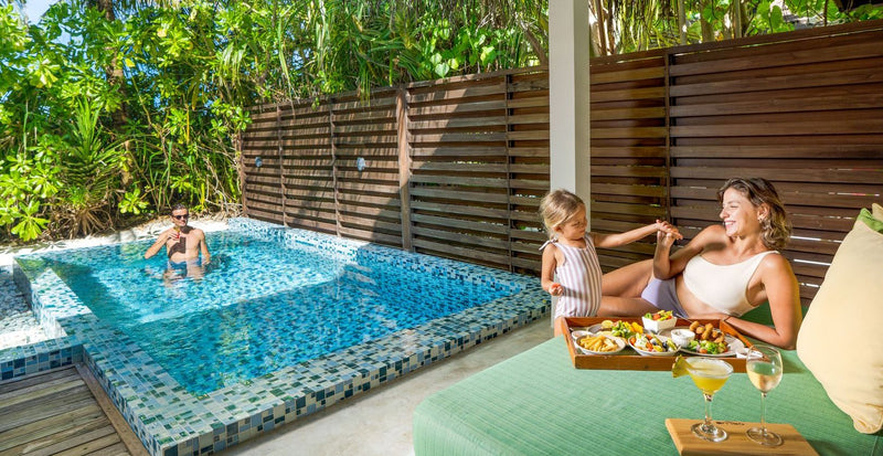 OBLU SELECT Sangeli, North Malé Atoll: a family in the garden pool of a beach villa, with a breakfast tray at the pool edge