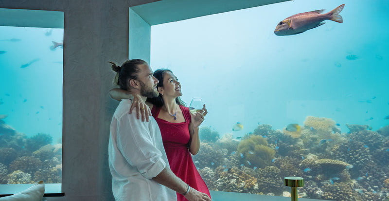 OBLU SELECT Lobigili, North Malé Atoll: a couple beside the glass wall of Only Blu, the underwater restaurant