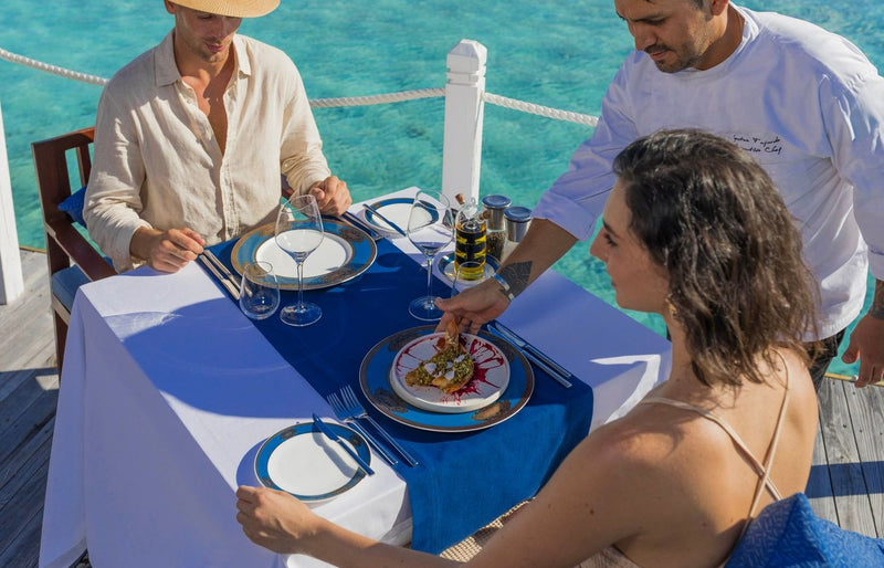 VARU by Atmosphere, North Malé Atoll: a chef serving a couple at a table over the water