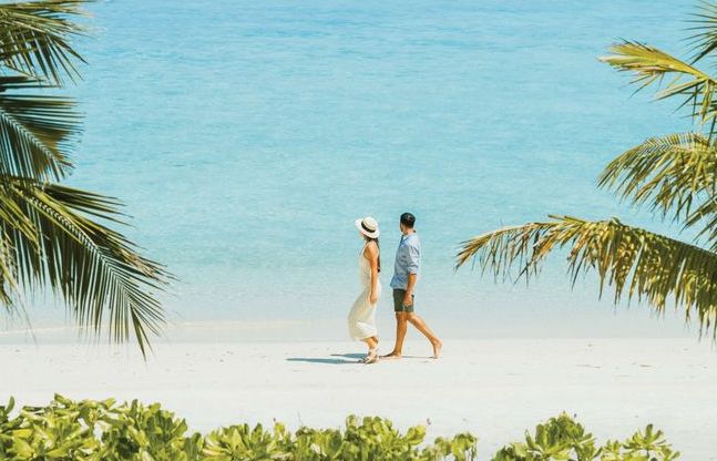 VARU by Atmosphere, North Malé Atoll: a couple walking along the beach