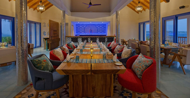OBLU NATURE Helengeli by SENTIDO, North Malé Atoll: a restaurant laid for dinner, with a blue-lit back wall