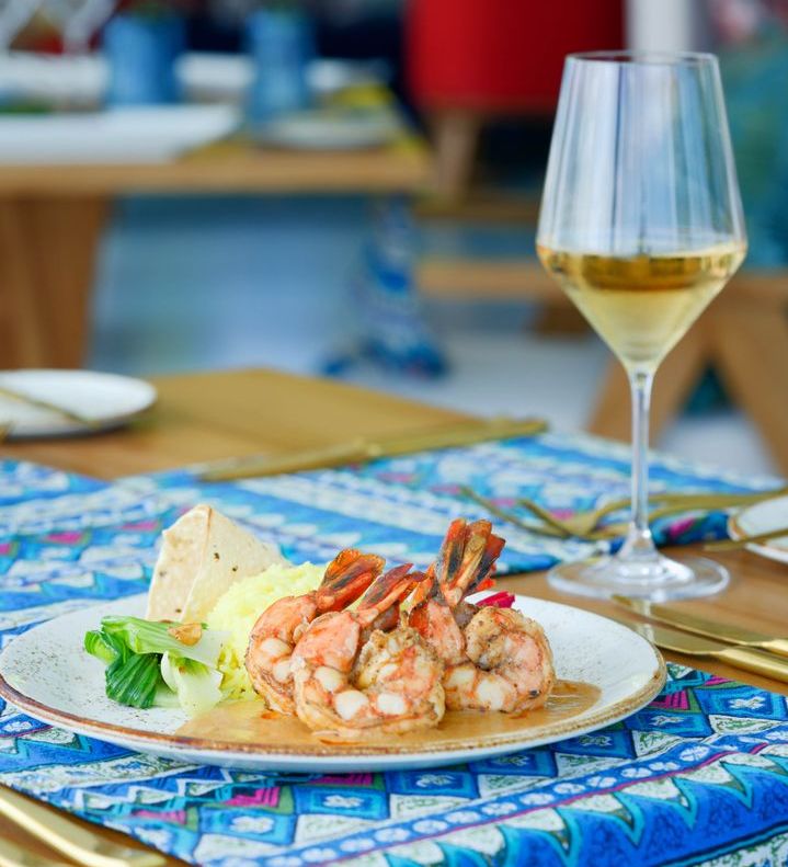 OBLU NATURE Helengeli by SENTIDO, North Malé Atoll: a plate of grilled prawns and a glass of white wine
