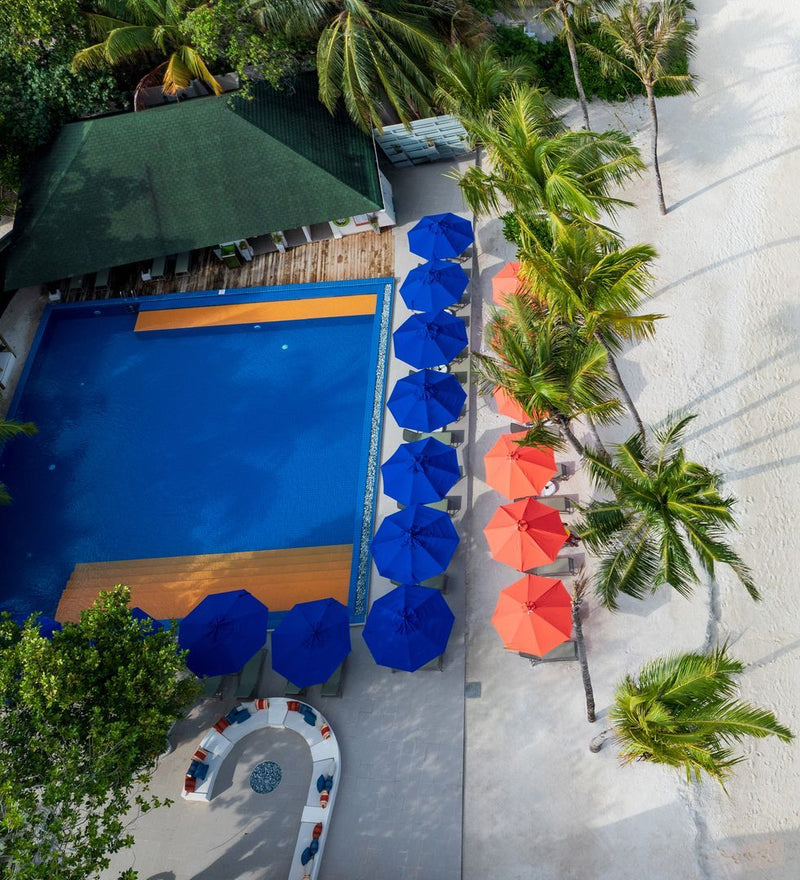 OBLU NATURE Helengeli by SENTIDO, North Malé Atoll: from above, the main pool and its row of blue and coral umbrellas
