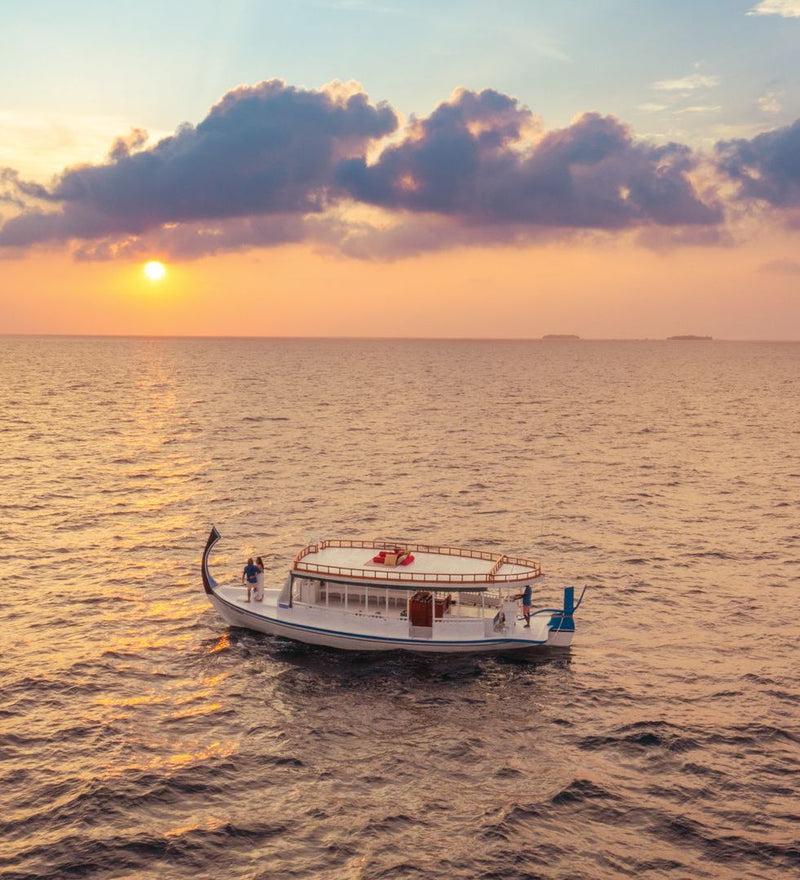 OBLU Xperience Ailafushi, North Malé Atoll: a boat on the sea at sunset
