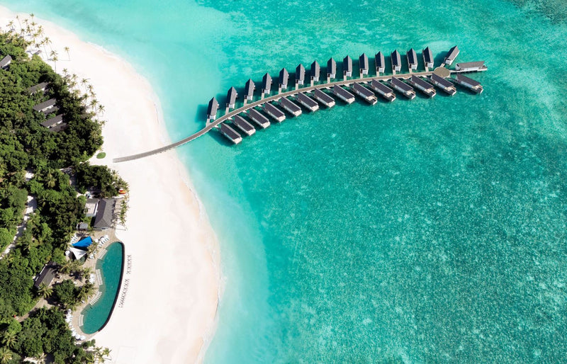 RAAYA by Atmosphere, Raa Atoll: from the air, the water villa jetty curving out from the beach