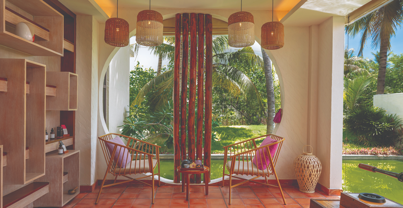 OBLU Xperience Ailafushi, North Malé Atoll: a lounge with cane chairs opening onto a garden