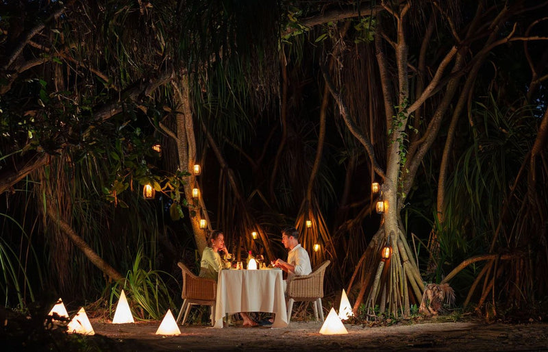 RAAYA by Atmosphere, Raa Atoll: a candlelit dinner for two under large trees at night